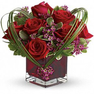 Κόκκινα τριαντάφυλλα σε γυαλί με εισαγωγής φυλλώματα