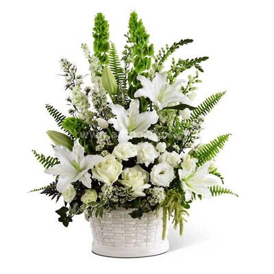 Flower arrangement in basket in white shade for funeral