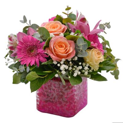 Γυάλινος κύβος σε ροζ αποχρώσεις με φρέσκα λουλούδια