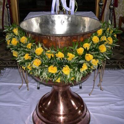 Βάπτιση για Αγόρι με γιρλάντα αποτελούμενη από κίτρινα φωτεινά τριαντάφυλλα και ελιά ως βάση
