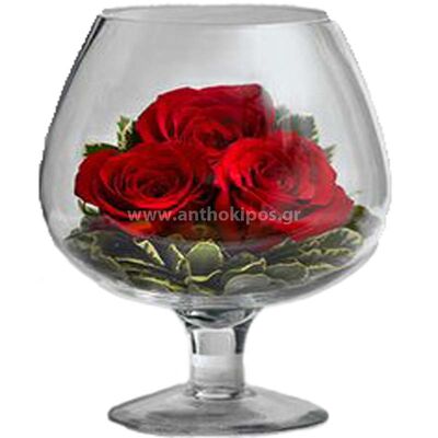 Τριαντάφυλλα και εισαγωγής φύλλωμα σε ποτήρι του κονιάκ