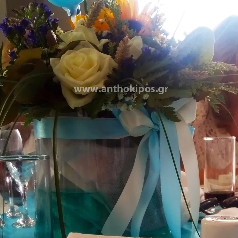 Βaptism for boy featuring arrangement with beautiful flowers